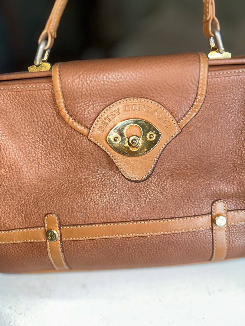 Betsy Gonzalez Boston Bag (Category: Luxury Bags & Wallets) located in Mandaluyong City. Submitted by TheWeekendProject (Listing ID 1400064602, Image 2). Description: Betsy Gonzalez New York Brown Leather Doctors Bag Top Handle Bag. Gladstone opening. Gold hardware. Outer zipper pocket and inner pockets. Pu Leather lining needs cleaning. Normal signs of use. Size 11” x 8” x 5” Base 13” Pickup Mandaluyong.