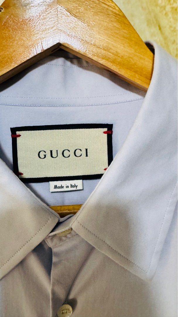 Gucci Light Blue Long Sleeve Shirt (Category: Luxury Apparel) located in Batangas. Submitted by cjayf (Listing ID 1400194646, Image 3). Description: - Authentic Gucci long sleeve shirt - Light blue color - Size 17 (43) - Made in Italy - Classic collar and button-down closure - Features Gucci branded buttons - Fabric: 96% cotton, 4% elastane - Includes care instructions on label.