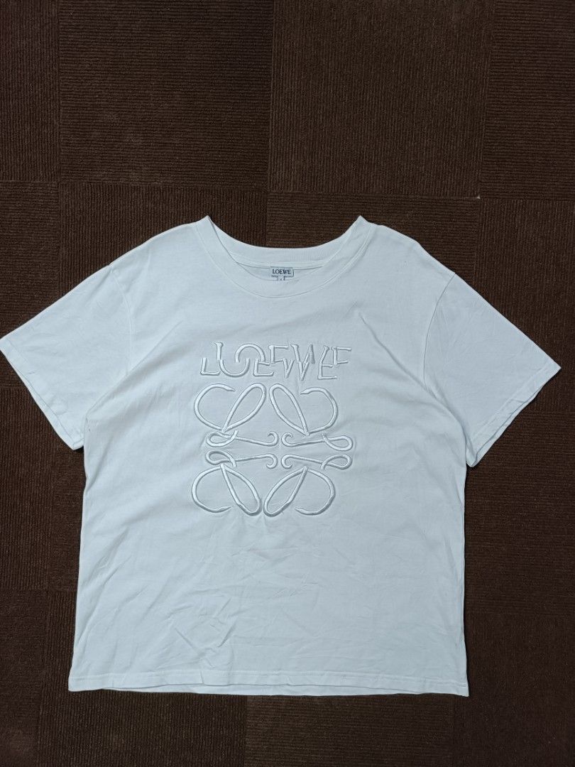 Loewe Embroidered Logo T-shirt (Category: Tshirts & Polo Shirts ) located in Magalang. Submitted by fourtwenthrift (Listing ID 1400187025, Image 1). Description: - Loewe White T-shirt - Size: L on tag - Features embroidered Loewe logo - Made in Portugal - Authentic brand label and care label included - Dimes: 22 x26.5 excellent near as new condition minimal washable dirt no issue.