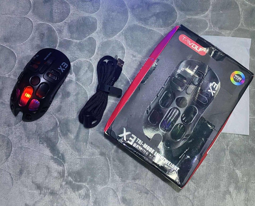T-WOLF X3 Wireless Charging Three-Mode Gaming Mouse (Category: Mouse & Mousepads) located in Manila. Submitted by elladejesus.05 (Listing ID 1400179458, Image 2). Description: T-WOLF X3 Wireless Gaming Mouse Brand New! - Three Connection Modes: 2.4G Wireless, Type-C, and Bluetooth 5.0 - High-Performance PAW3311 Sensor - Eye-catching RGB Lighting - Wireless Charging Capability - Long-lasting 500mAh Battery - Stylish Black Design - Unique "Hole in 