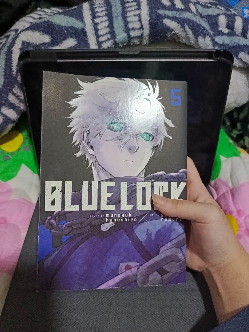 Blue Lock Manga Volume 5 (Category: Comics & Manga) located in Tacloban City. Submitted by lex.g04 (Listing ID 1400360144, Image 1). Description: Blue Lock manga volume 5. Features the story by Muneyuki Kaneshiro and art by Yusuke Nomura. The cover shows a character with white hair and green eyes. The back cover has a blue and black design with text. The spine shows the title and volume number..