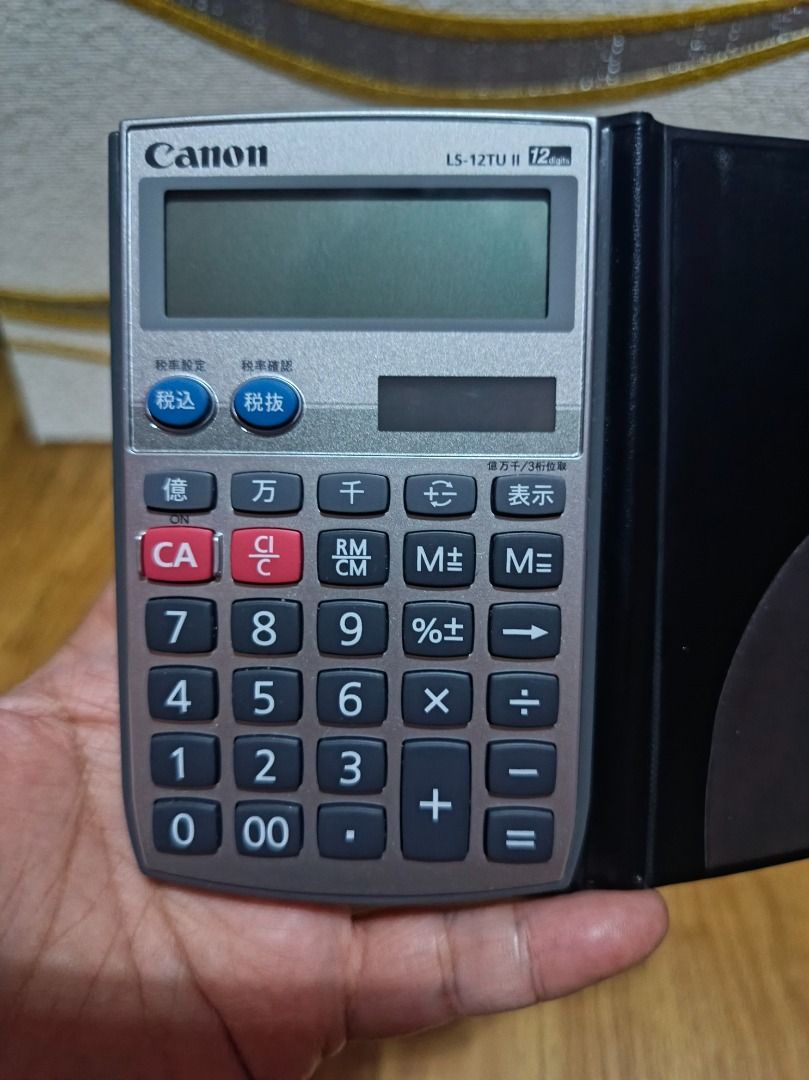 CANON LS-12TU II CALCULATOR (Category: Stationery & School Supplies) located in Makati City. Submitted by nyxhemera26 (Listing ID 1400337140, Image 2). Description: CANON LS-12TU II CALCULATOR - 300 • WORKING. LIKE NEW The product in the image is a Canon LS-12TU II calculator. It is a 12-digit handheld calculator with a soft wallet cover. Tax Function: It has tax calculation functions, including "tax included" (税込) and "tax excluded" (税抜) buttons