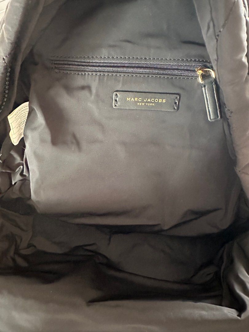 Marc Jacobs Quilted Backpack （分類：背囊）位於 Hong Kong。 由 cwai07 提交（商品編號 1400221163，圖片 2）。簡介： Black quilted backpack by Marc Jacobs. Features a front pocket and a main compartment with a zipper closure. The interior includes a small pocket. The backpack has adjustable straps and a top handle. The Marc Jacobs logo is visible on the front and inside the bag.。