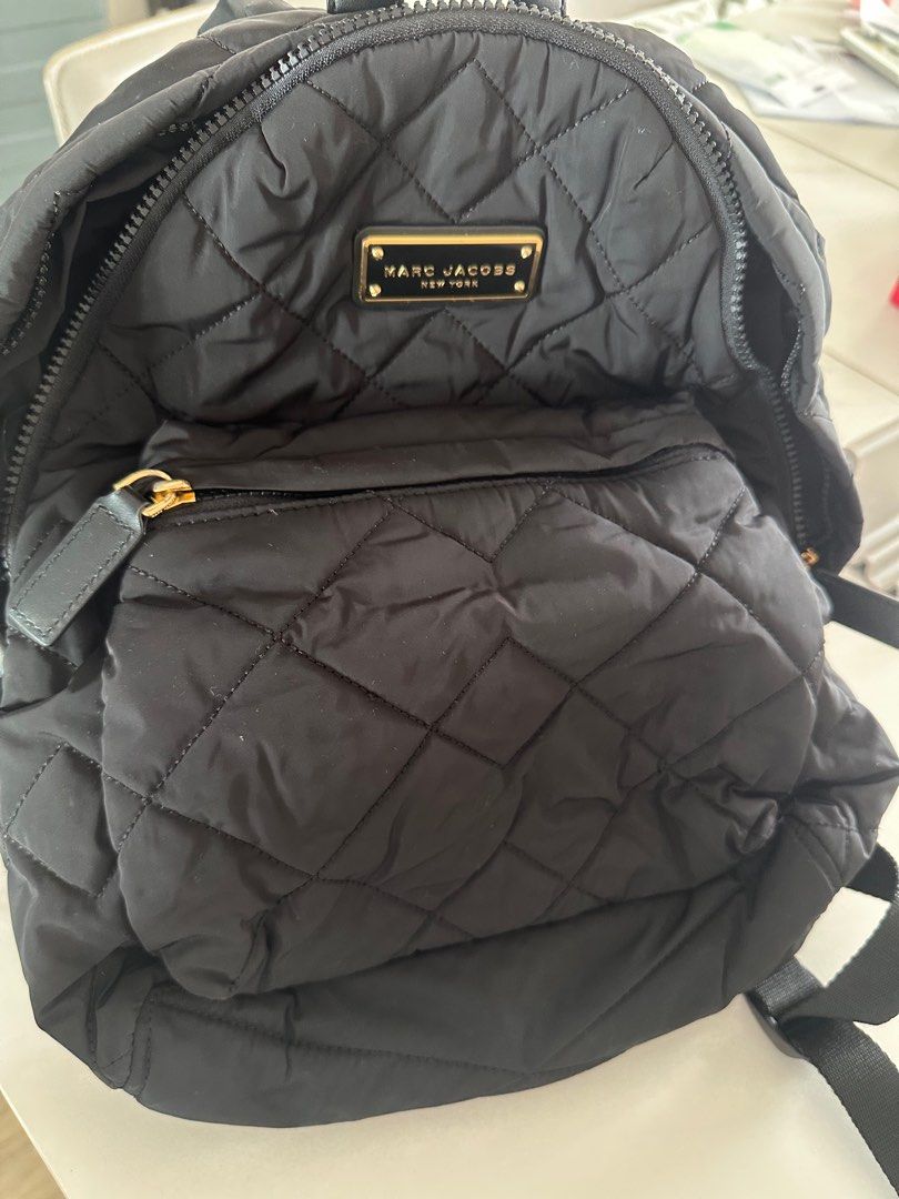 Marc Jacobs Quilted Backpack （分類：背囊）位於 Hong Kong。 由 cwai07 提交（商品編號 1400221163，圖片 3）。簡介： Black quilted backpack by Marc Jacobs. Features a front pocket and a main compartment with a zipper closure. The interior includes a small pocket. The backpack has adjustable straps and a top handle. The Marc Jacobs logo is visible on the front and inside the bag.。