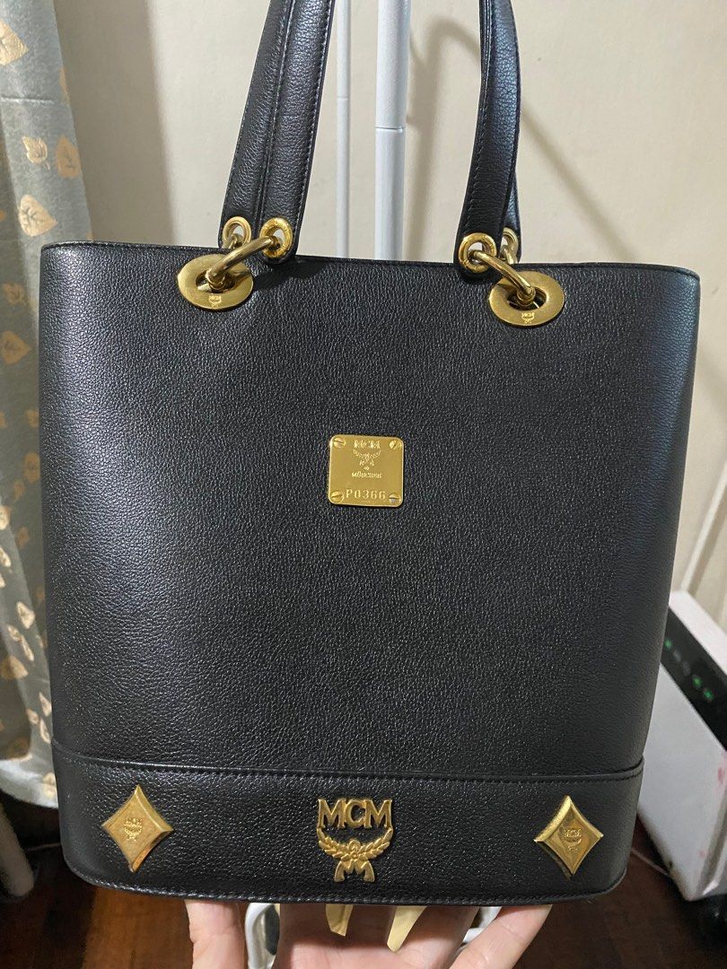 MCM Black Tote Bag (Category: Luxury Bags & Wallets) located in Caloocan City. Submitted by switspice (Listing ID 1400347437, Image 2). Description: - Black MCM tote bag - Gold-tone hardware - Rectangular shape with structured base - Main compartment with interior pockets - Dual top handles - Gold MCM logo on front - MCM logo inside.