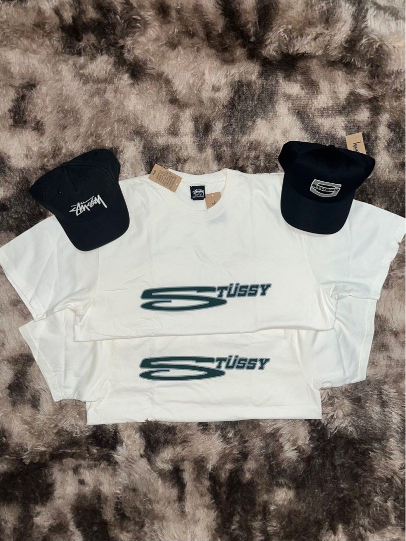 Stüssy T-shirts and Caps (Category: Tshirts & Polo Shirts ) located in Caloocan City. Submitted by kristoperlim (Listing ID 1400309802, Image 1). Description: Stüssy T-shirts and caps. The T-shirts are white with a green and black logo. ₱5500 Stussy Caps ₱5500.