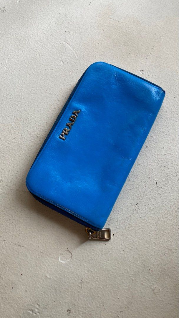 Authentic Prada Long Zipped Wallet (Category: Luxury Bags & Wallets) located in Mandaluyong City. Submitted by material_boi (Listing ID 1400435938, Image 1). Description: Made in Italy. Soft leather, I think calf. Lampo zippers. 7.5 inches wide and 4 inches long. Very roomy! Marami ka malagay. Inside is clean. Coin compartment is zipped as well. Smooth zippers. Hardware not so gold na but maganda pa. Issues: this has been repainted to Azure Blue 