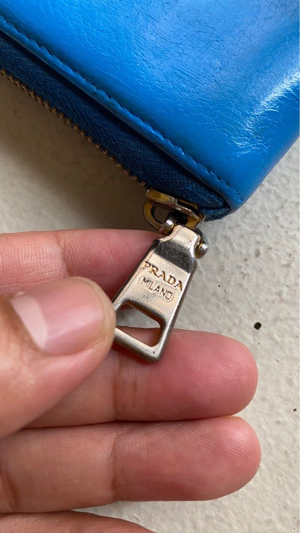 Authentic Prada Long Zipped Wallet (Category: Luxury Bags & Wallets) located in Mandaluyong City. Submitted by material_boi (Listing ID 1400435938, Image 3). Description: Made in Italy. Soft leather, I think calf. Lampo zippers. 7.5 inches wide and 4 inches long. Very roomy! Marami ka malagay. Inside is clean. Coin compartment is zipped as well. Smooth zippers. Hardware not so gold na but maganda pa. Issues: this has been repainted to Azure Blue 