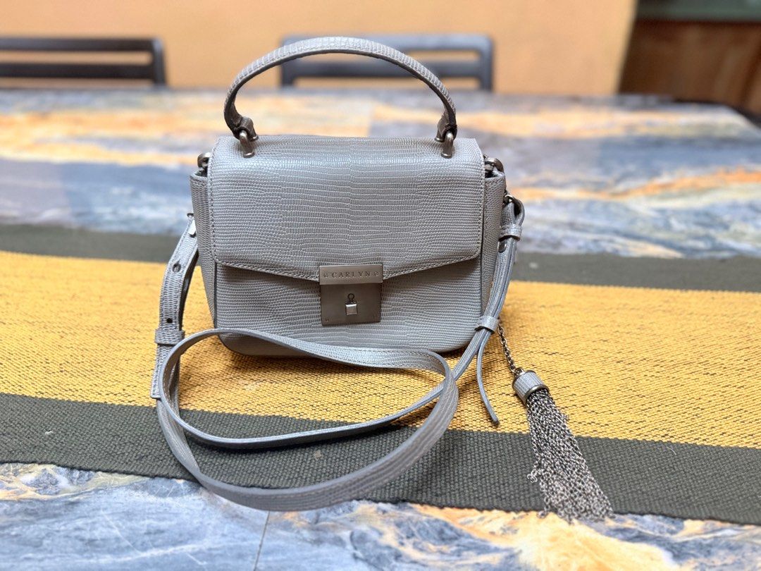 Carlyn Handbag with Tassel (Category: Luxury Bags & Wallets) located in Bacolod City. Submitted by rubilena (Listing ID 1400503960, Image 1). Description: - Light grey Carlyn handbag - Top handle and detachable shoulder strap - Flap closure with metallic lock - Decorative tassel - Textured exterior - Perfect for everyday use.
