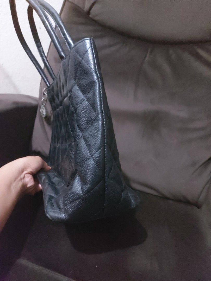 Chanel Black Quilted Tote Bag (Category: Luxury Bags & Wallets) located in Tagum. Submitted by padaslydia82022 (Listing ID 1400496819, Image 3). Description: - Black quilted tote bag - Double handles - Large CC logo - Zipper closure - Silver-tone charm - Multiple interior compartments - Chanel label - Leather material - Shows wear on the bottom.