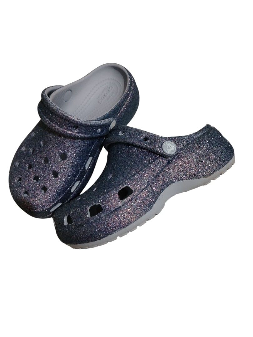 Crocs Classic Glitter Clogs PURPLE MOON PLATFORM (Category: Wedges) located in Manila. Submitted by nikaclyde (Listing ID 1400475514, Image 2). Description: PURPLE MOON glitter Crocs PLATFORM Clogs. Features the iconic Crocs comfort footbed. Size W5. The shoes have the Crocs logo on the footbed. The soles show some wear. These clogs are perfect for casual wear and offer a comfortable fit..