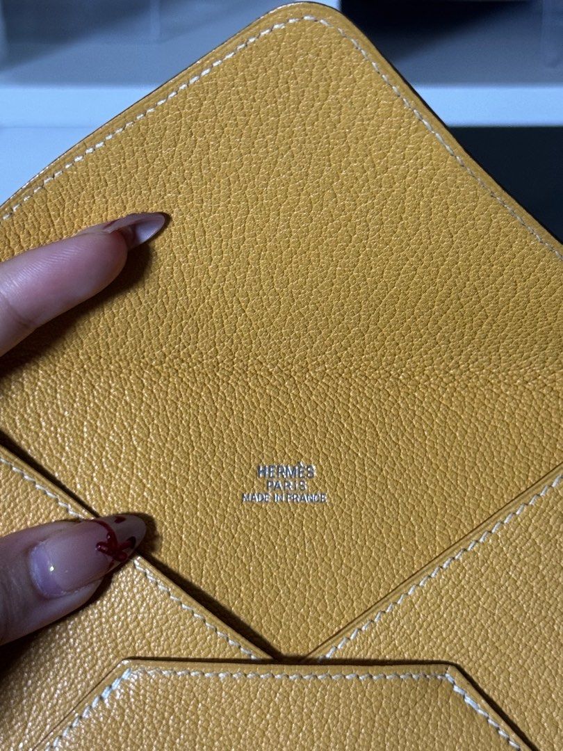 Hermes Envelope Wallet (Category: Luxury Bags & Wallets) located in Manila. Submitted by sacreluxebyelly (Listing ID 1400581248, Image 2). Description: - Authentic Hermes envelope wallet - Vibrant yellow color - Unique geometric design - White stitching detail - Features the Hermes logo - "Made in France" stamp inside - Stylish and functional for everyday use.