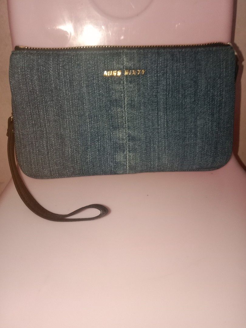 Miss Sixty Denim Wallet (Category: Wallets & Card holders) located in Bulacan. Submitted by chubbylicious (Listing ID 1400431121, Image 1). Description: Listing includes two wallets. One is a denim wallet with the brand name "Miss Sixty" on the front. It has a wrist strap and multiple compartments inside. The other wallet has a colorful floral and bird design. It has a zipper closure and multiple card slots..
