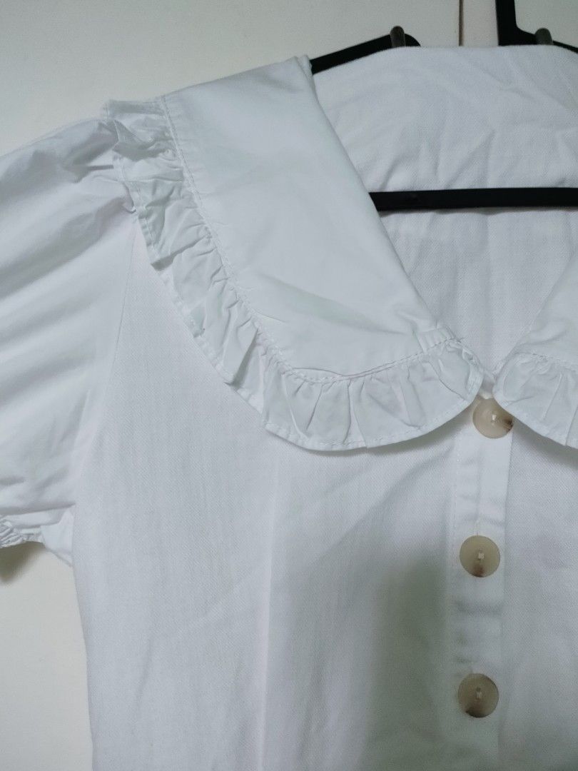 Premium White Linen Collar Dress (Category: Dresses) located in Makati City. Submitted by declutteriaa_mama (Listing ID 1400460745, Image 3). Description: - White dress - Fits small to medium body frames - Peter Pan collar with ruffle trim - Short, puffed sleeves - Button-down front - Fitted waist - Slightly flared skirt - Length: 34 inches.