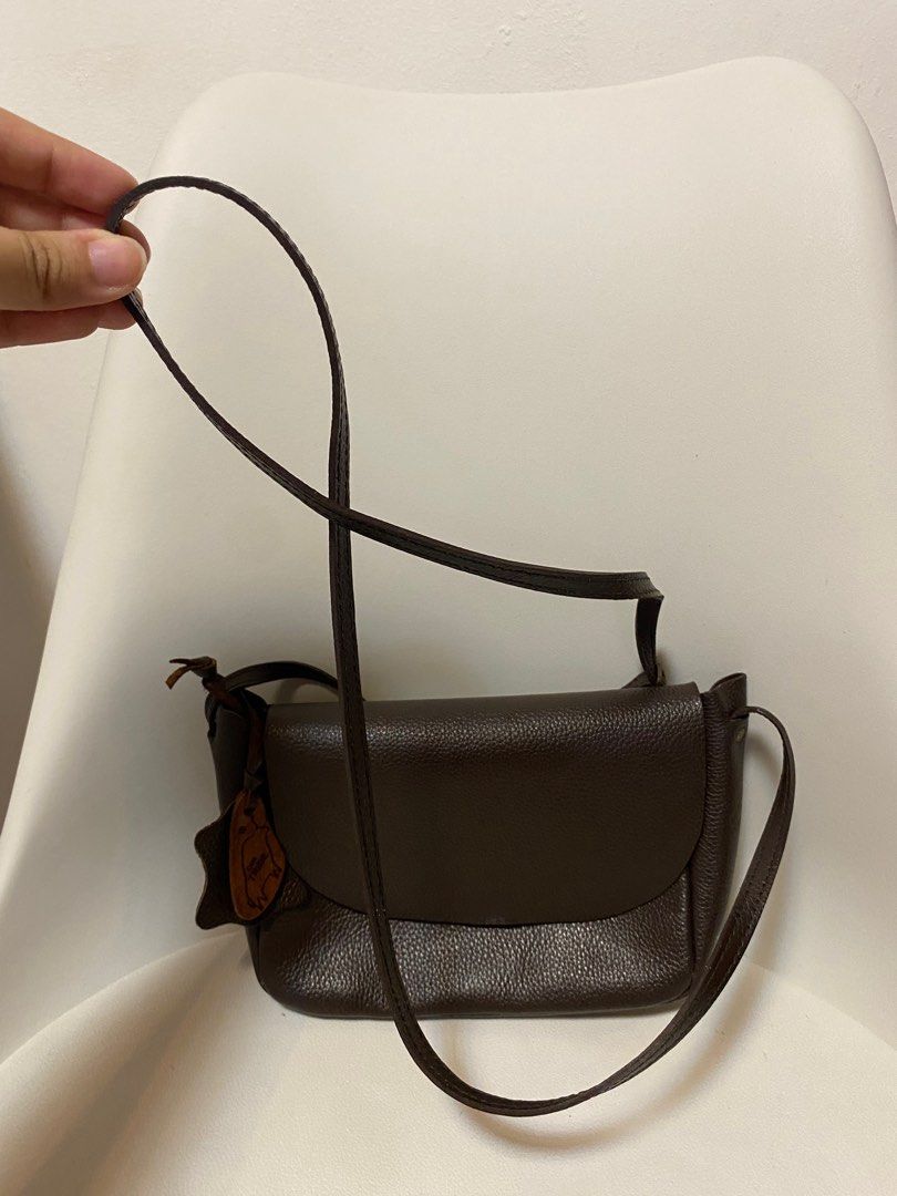 Our Tribe Brown Leather Crossbody Bag (Category: Cross-body Bags) located in Quezon City. Submitted by raever_callejo (Listing ID 1400701544, Image 2). Description: No cancellations Can send more photos MOP: GCash/Maya/BPI Loc: Novaliches, Quezon City MOD: Lalamove/Grab/GGX- Brown leather crossbody bag - Flap closure - Adjustable strap - Textured exterior - Single main compartment - Includes small leather tag - Suitable for everyday wear.