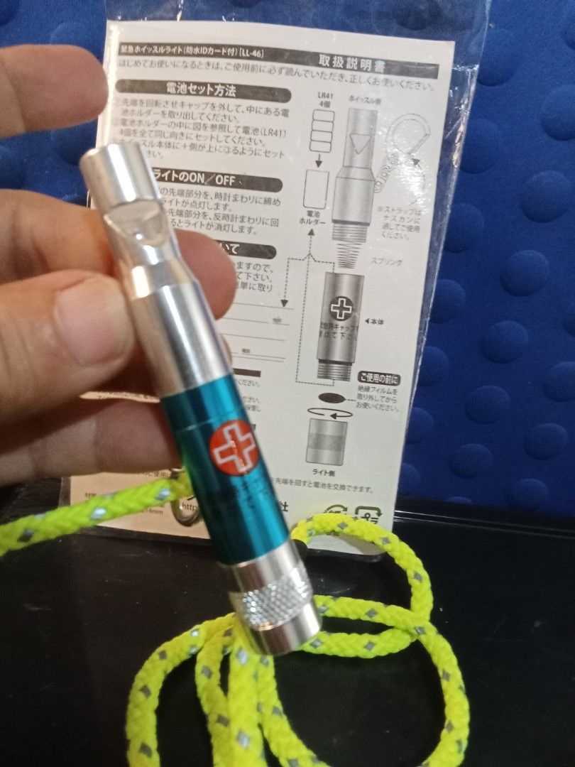 Emergency Whistle with built in Light (Category: Lighting) located in Bocaue. Submitted by marajapansurplus (Listing ID 1400644222, Image 3). Description: - Emergency whistle with built-in light - Includes a convenient lanyard - Features a medical cross design - Made of durable metal - Stylish blue and silver color scheme - Comes with instructions in Japanese - Perfect for emergencies and outdoor activities.