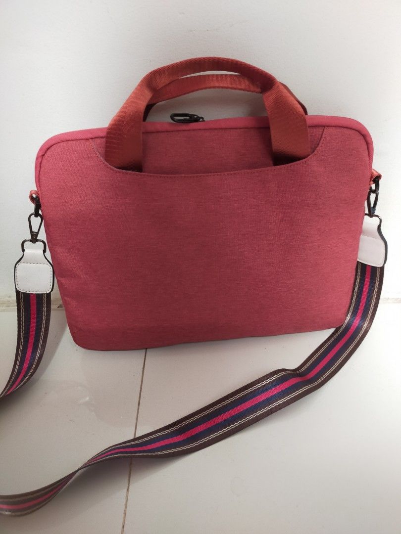 Halo Laptop Bag (Category: Laptop Bags & Sleeves) located in Mandaue City. Submitted by noligaga.dolphin (Listing ID 1400634307, Image 2). Description: Halo laptop bag features a vibrant rust color with a matching shoulder strap. It has a front pocket and a top handle for easy carrying. The bag has a zipper closure and a stylish striped shoulder strap. The interior is lined with a pad & fabric. There is mark on the handles. Used but looks new Fit