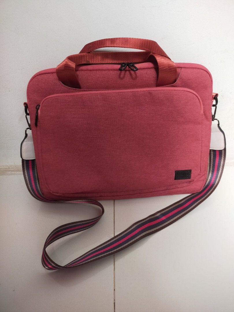 Halo Laptop Bag (Category: Laptop Bags & Sleeves) located in Mandaue City. Submitted by noligaga.dolphin (Listing ID 1400634307, Image 1). Description: Halo laptop bag features a vibrant rust color with a matching shoulder strap. It has a front pocket and a top handle for easy carrying. The bag has a zipper closure and a stylish striped shoulder strap. The interior is lined with a pad & fabric. There is mark on the handles. Used but looks new Fit