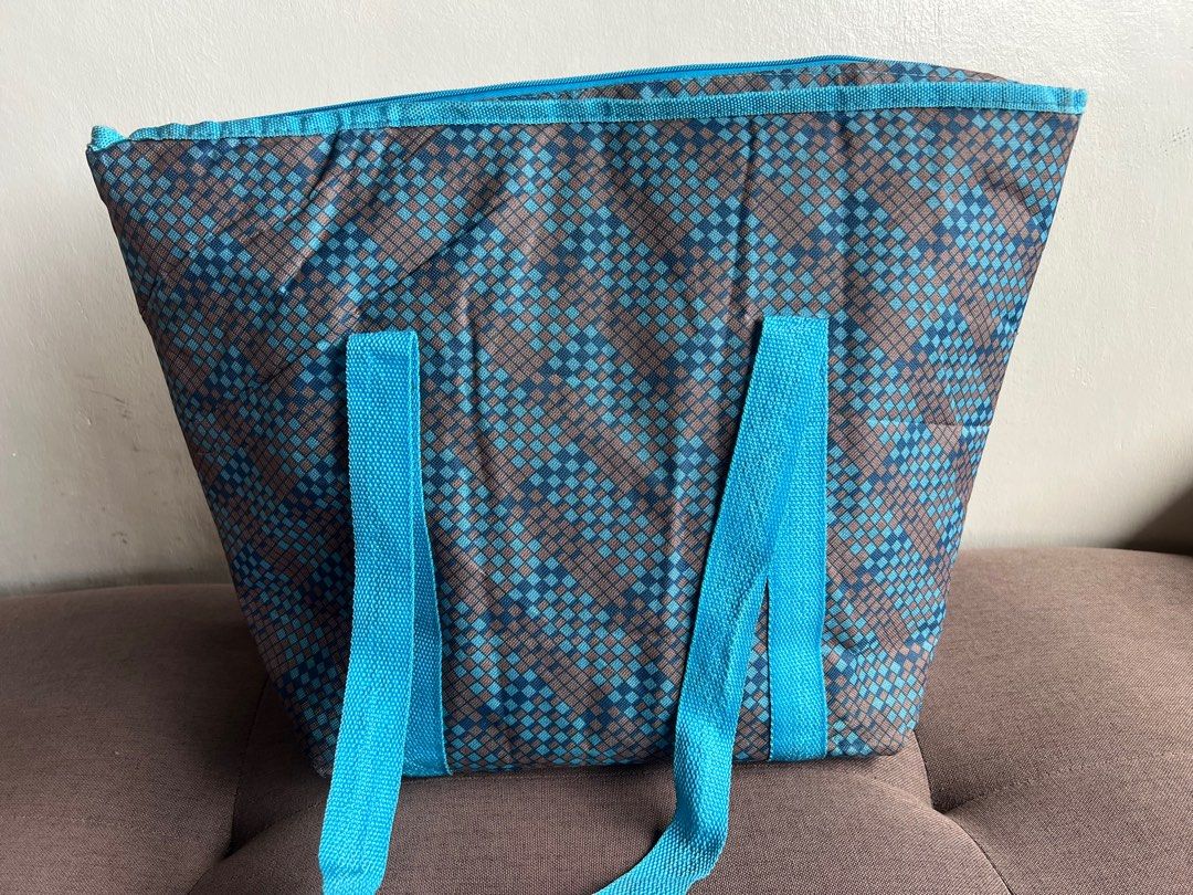 Insulated Cooler Bag (Category: Food Organization & Storage) located in Quezon City. Submitted by cristintin (Listing ID 1400622627, Image 2). Description: Insulated cooler bag is perfect for keeping your food and drinks cold. It features a blue and brown geometric pattern, a mesh pocket on the front, and sturdy blue handles. The interior is lined with a silver insulated material. It has a zipper closure to keep contents secure. Made in China..