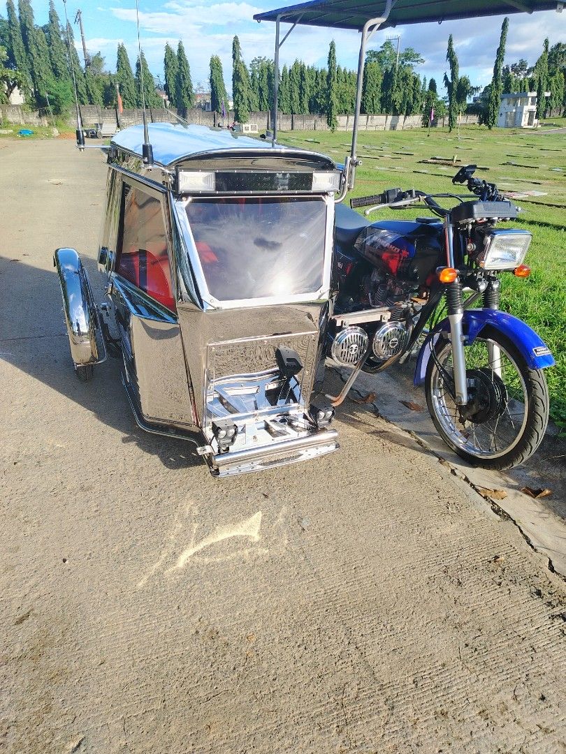 Motorcycle with Sidecar (Category: Motorbikes for Sale) located in Manila. Submitted by bojisantos54140 (Listing ID 1400730361, Image 1). Description: Motorcycle with a sidecar. The motorcycle has a blue front fender and a black and blue painted body. The sidecar is made of stainless steel with a roof. It has a windshield and a red interior. The motorcycle has a headlight and two horns..