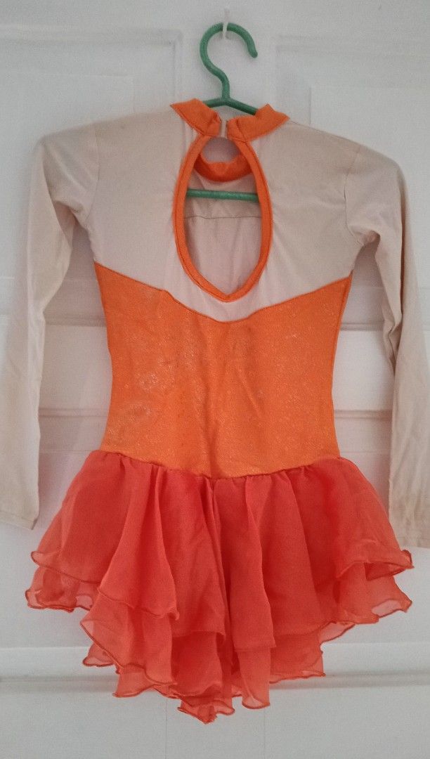 Orange Dance Leotard / figure skating dress (Category: Babies & Kids Fashion) located in Paranaque City. Submitted by yesyesyo (Listing ID 1400640677, Image 2). Description: Dance leotard features a vibrant orange bodice and skirt, complemented by beige sleeves and upper back. It has a keyhole back design and a high neckline. The skirt is layered with a flowing, ruffled effect. waist when laid flat: 10" length: 22" stretchchable tailored for my d