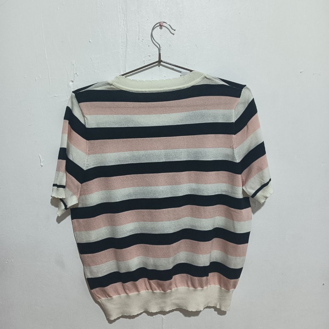 Striped Knit Top (Category: Blouses) located in Caloocan City. Submitted by appletastic (Listing ID 1400690018, Image 2). Description: Knit top features a classic striped pattern in black, pink, and white. It has a round neckline and short sleeves with a scalloped edge. The bottom hem also has a scalloped design. The blouse is fit for any size through its stretchable fabric. The top is hanging on a metal hanger. The original price of PHP 349.75 i