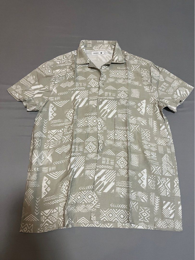 Terranova Printed Short Sleeve Shirt (Category: Tshirts & Polo Shirts ) located in Tarlac. Submitted by johnjohnjohn23 (Listing ID 1400647676, Image 1). Description: - Terranova short sleeve shirt - Unique printed design - Collared neckline - Button-down closure - Neutral color with white geometric patterns - Size: Medium - Measurements in images - Perfect for casual wear.