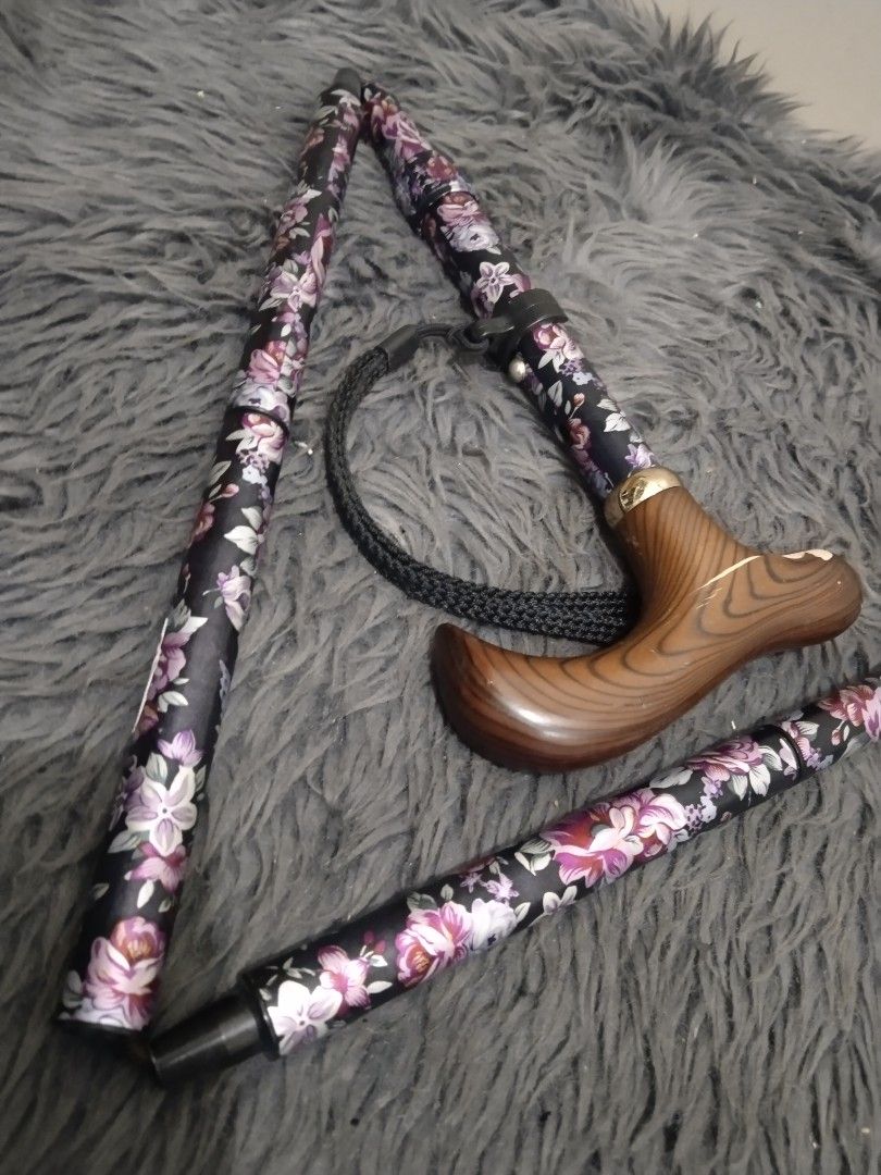 Affordable foldable walking cane/stick 😍👌 (Category: Medical Supplies & Tools) located in Malolos. Submitted by afford.japan (Listing ID 1400926622, Image 2). Description: - Floral design on a black background - Wooden handle - Includes wrist strap - Folds for easy storage and transport - Rubber tip for stability - Stylish and practical mobility aid.