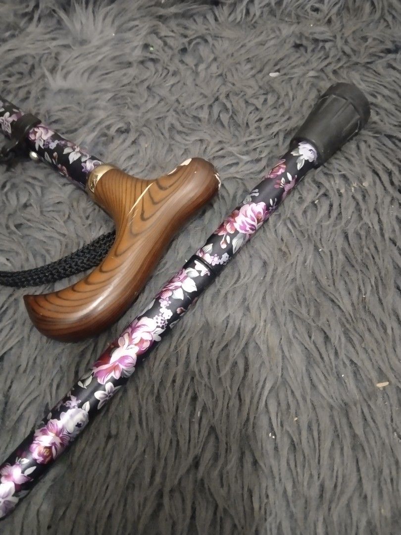 Affordable foldable walking cane/stick 😍👌 (Category: Medical Supplies & Tools) located in Malolos. Submitted by afford.japan (Listing ID 1400926622, Image 3). Description: - Floral design on a black background - Wooden handle - Includes wrist strap - Folds for easy storage and transport - Rubber tip for stability - Stylish and practical mobility aid.
