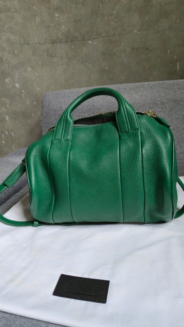 Alexander Wang Emerald Green Handbag (Category: Luxury Bags & Wallets) located in Meycauayan. Submitted by tuschy (Listing ID 1400796077, Image 3). Description: - Emerald green handbag - Top handle and detachable shoulder strap - Zip closure - Gold-tone hardware - Textured leather exterior - Black interior lining - Includes dust bag - Gold studs on the bottom.