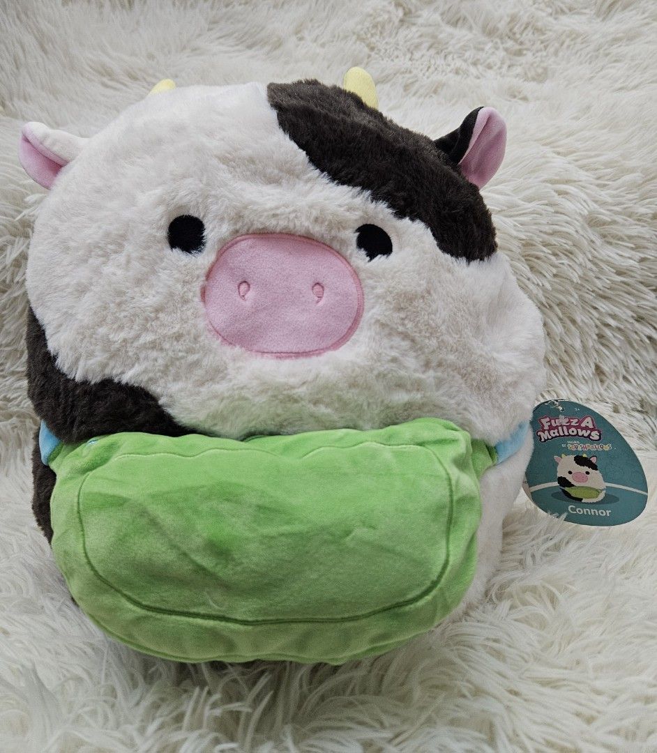 Fuzzamallows Connor the Cow Plush (Category: Plushies & Soft Toys) located in Taguig. Submitted by wonderworksbyjanele (Listing ID 1400958944, Image 1). Description: - Fuzzamallows Connor the Cow plush - Soft and fluffy texture - Black and white cow design - Includes a green pouch - Comes with original tag - Perfect for cuddling or display.