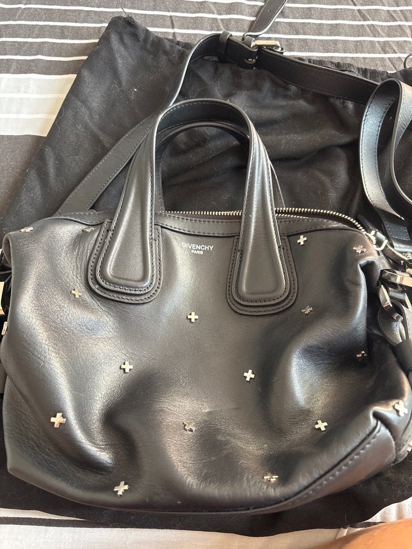 Givenchy Nigthingale Studded Handbag (Category: Luxury Bags & Wallets) located in Las Pinas. Submitted by ochey20 (Listing ID 1400829020, Image 1). Description: Black Givenchy Nigthingale 2 way bag with cross studs. Features a top handle and a detachable shoulder strap. The interior includes a zippered pocket. Includes a dust bag. The bag has a zipper closure. The Givenchy logo is visible on the exterior and interior. ** Authencity not guaranteed