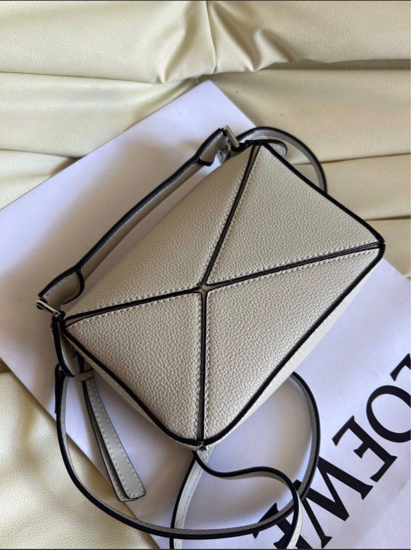 Loewe Puzzle Mini Bag (with box) (Category: Luxury Bags & Wallets) located in Taytay. Submitted by darkswan016 (Listing ID 1400826193, Image 2). Description: Bought this from carousell 2 months ago. Rfs: too small for me. Cannot guarantee authenticity. - Loewe Puzzle Mini Bag - Light grey color - Unique geometric design - Top handle and detachable shoulder strap - Interior with herringbone lining - Made in Spain.