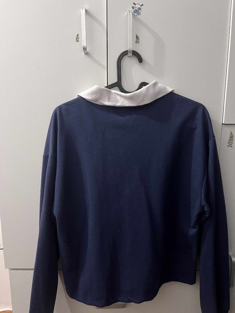 Penshoppe Crop Long Sleeve (Category: Tshirts & Polo Shirts ) located in General Trias. Submitted by pepperbits (Listing ID 1400789428, Image 2). Description: - Color: Navy blue - Features a white collar - Small embroidered logo on the chest - Long-sleeved - Button-up neckline - Cropped style - Plain navy blue back.