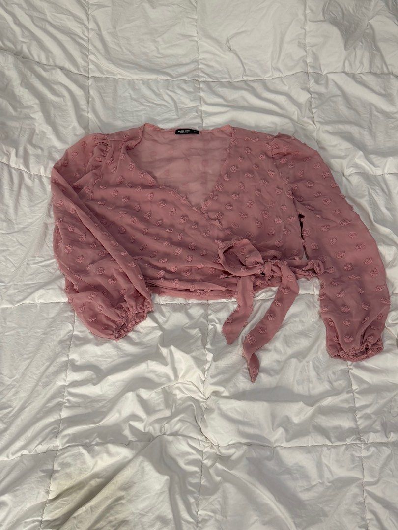 Pink Wrap Blouse (Category: Blouses) located in Quezon City. Submitted by anjvb (Listing ID 1400788147, Image 1). Description: - Pink wrap blouse - Long sleeves - V-neckline - Tie closure at waist - Textured, dotted fabric - Gathered cuffs - Lightweight material.