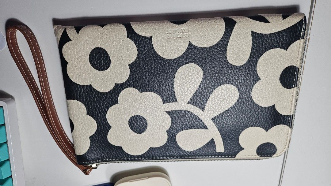 Caroline Gardner Floral Print Clutch (Category: Clutches) located in Quezon City. Submitted by jaggerlexy (Listing ID 1401161480, Image 2). Description: - Black and white floral pattern - Wrist strap - Zip closure - Striped lining - Multiple card slots - Zippered pocket - Textured material - Perfect for essentials.