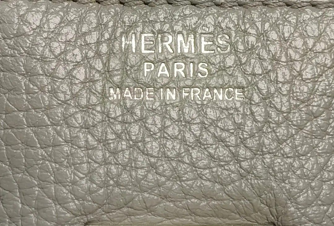 Hermès Paris Handbag (Category: Luxury Bags & Wallets) located in Digos. Submitted by chihanu (Listing ID 1401027075, Image 2). Description: - Hermès Paris handbag - Grey leather exterior - Top handle design - Flap closure with turn lock - Zipper closure - Silver-toned hardware - Made in France - Interior with multiple compartments - Minor signs of wear on the interior.