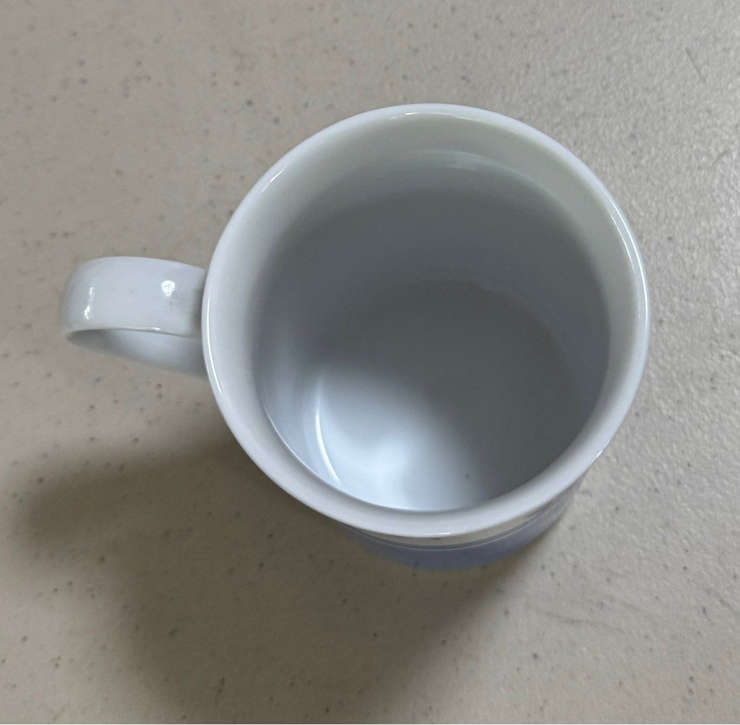 Hutschenreuther Summerdream Blue Mug (Category: Coffee & Tea Tableware) located in Quezon City. Submitted by meggoquingco (Listing ID 1401049893, Image 3). Description: Hutschenreuther mug from the Summerdream Blue collection. It is made in Germany. The mug has a white base with a handle. The bottom of the mug features the brand name, collection name, and the country of origin. The mug has a simple, elegant design..