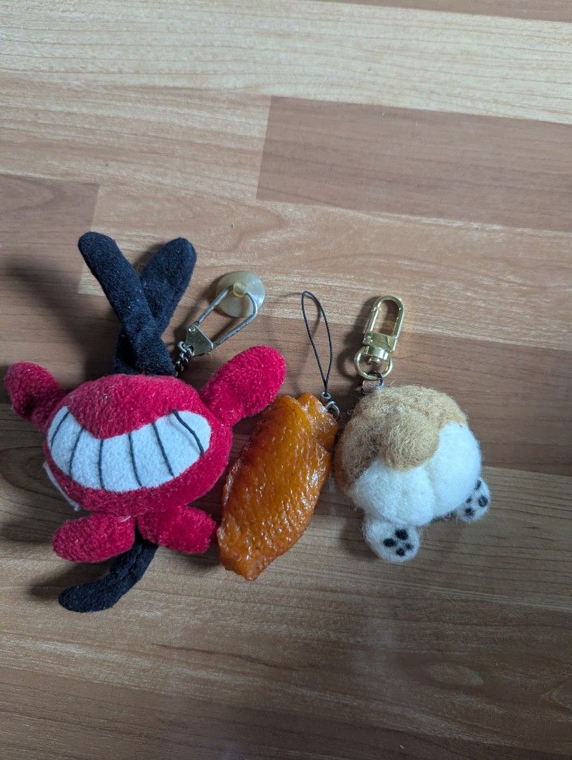 Keychain Set - Devil, Chicken Wing, Corgi Butt (Category: Plushies & Soft Toys) located in Palayan City. Submitted by sarahgeeshop (Listing ID 1401015125, Image 1). Description: - Adorable keychain set! - Includes: - Red devil plushie with smiling face, horns, and tail. - Chicken wing charm. - Corgi butt plushie with cute paws. - Each keychain has a clasp or loop for easy attachment to bags or keys..