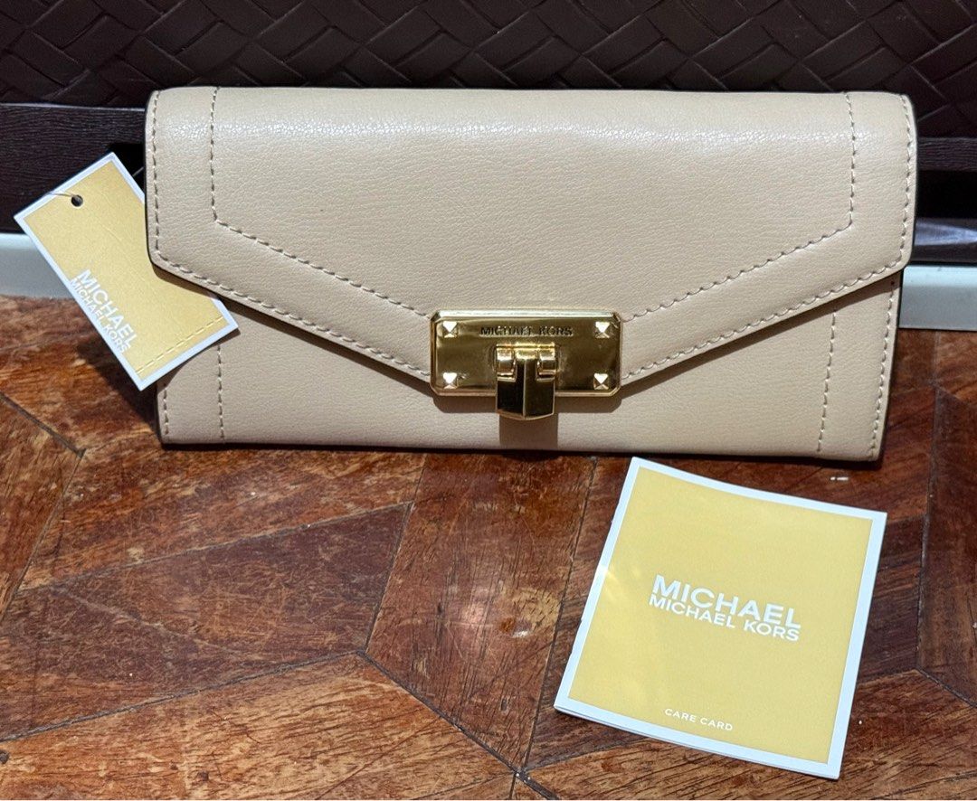 Michael Kors Beige Wallet (Category: Luxury Bags & Wallets) located in San Pedro. Submitted by cathy_paras (Listing ID 1401141736, Image 1). Description: Brand New Michael Kors Kinsley large carryall leather wallet. *The wallet is a bifold or trifold design with a gold-tone clasp featuring the “MICHAEL KORS” logo. *It is made of leather and has a structured, envelope-style flap. *The color appears to be a neutral shade, such as beige or nude. *Th