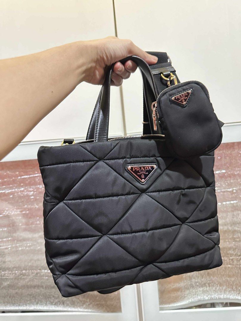 Prada Quilted Tote Bag with Pouch (Category: Luxury Bags & Wallets) located in Taguig. Submitted by thummert (Listing ID 1401074304, Image 2). Description: - Authentic Prada tote bag - Quilted design - Detachable shoulder strap - Top handles - Matching small pouch included - Secure zipper closure - Prada logo on front and strap - Silver hardware.