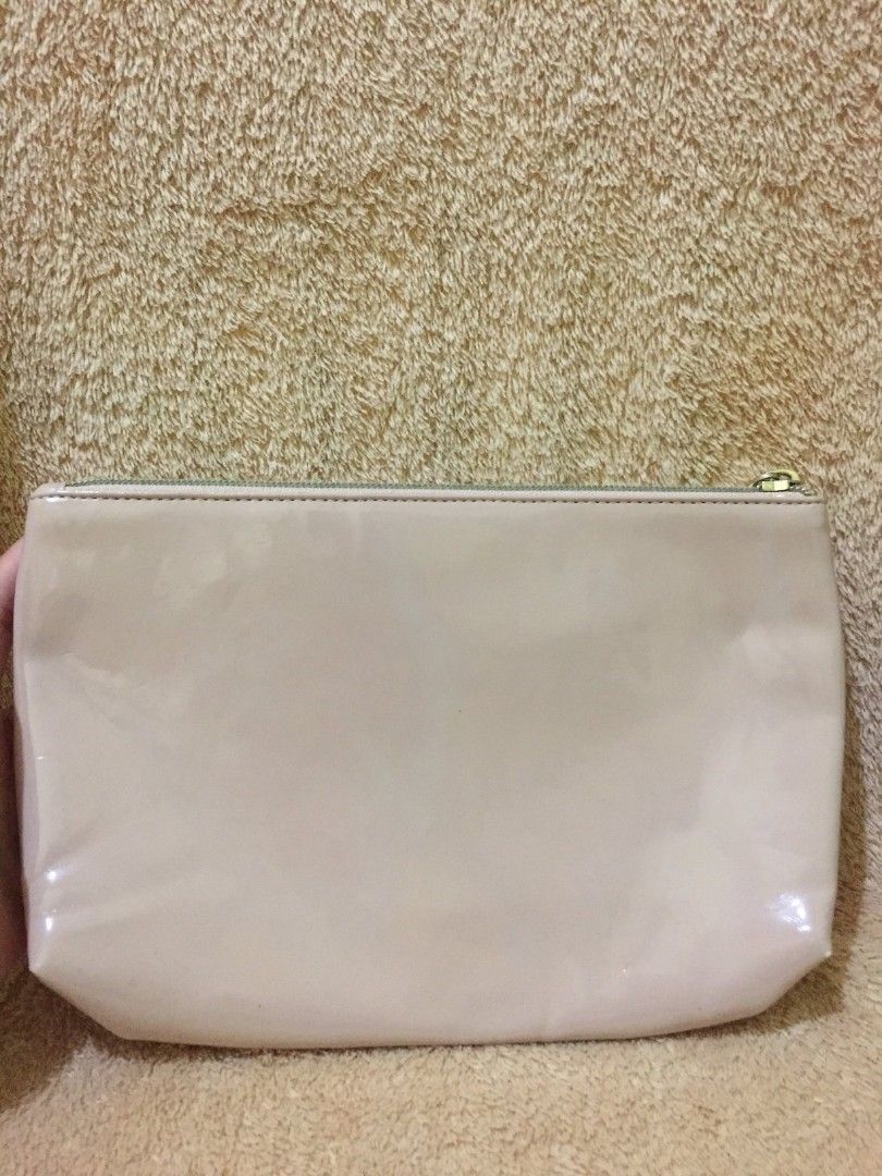 Salvatore Ferragamo Clutch (Category: Luxury Bags & Wallets) located in Bulacan. Submitted by assorted.items (Listing ID 1401125141, Image 2). Description: Peach clutch from Salvatore Ferragamo. It features a zip closure and a subtle embossed logo. The interior is lined with a light-colored fabric. Made in Italy..