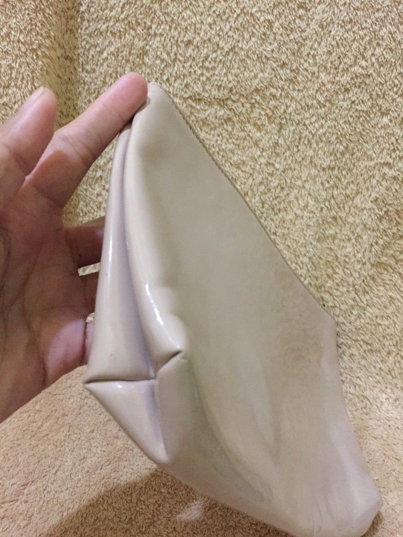 Salvatore Ferragamo Clutch (Category: Luxury Bags & Wallets) located in Bulacan. Submitted by assorted.items (Listing ID 1401125141, Image 3). Description: Peach clutch from Salvatore Ferragamo. It features a zip closure and a subtle embossed logo. The interior is lined with a light-colored fabric. Made in Italy..