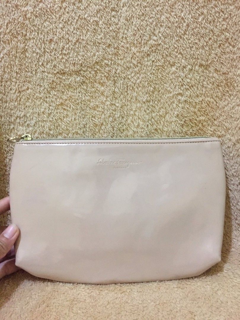Salvatore Ferragamo Clutch (Category: Luxury Bags & Wallets) located in Bulacan. Submitted by assorted.items (Listing ID 1401125141, Image 1). Description: Peach clutch from Salvatore Ferragamo. It features a zip closure and a subtle embossed logo. The interior is lined with a light-colored fabric. Made in Italy..