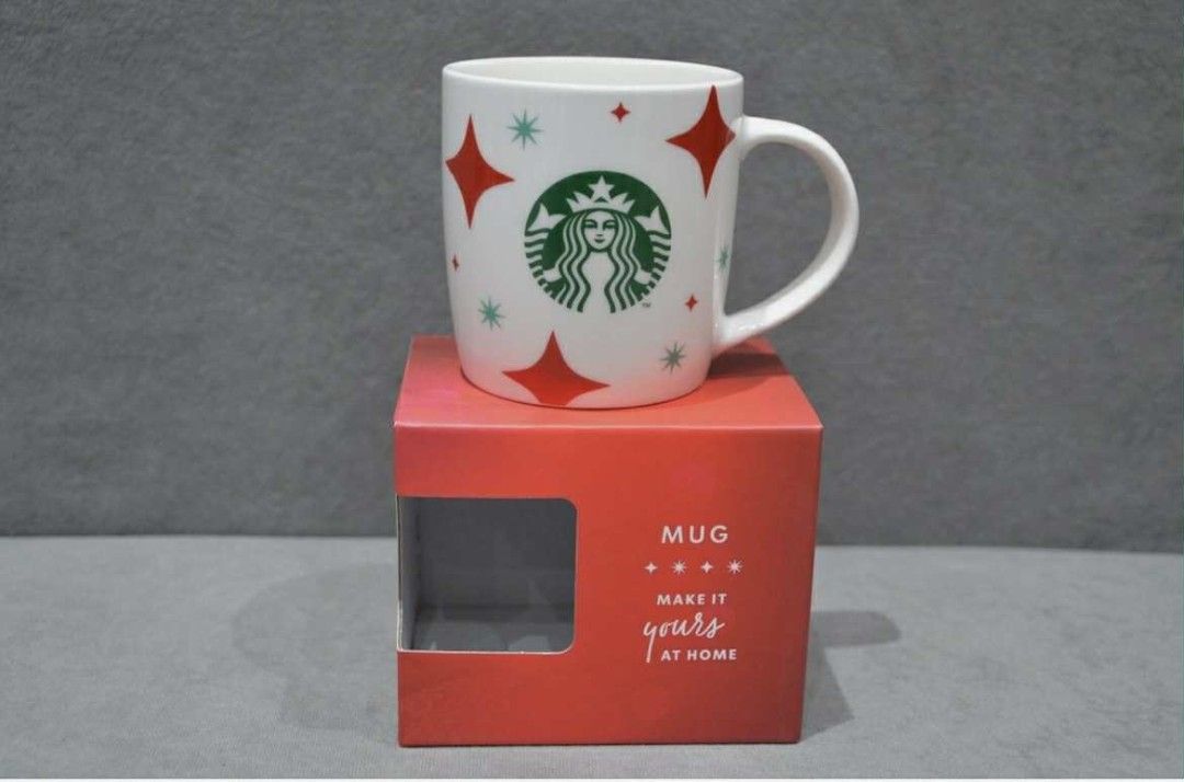 Starbucks Holiday Mug (Category: Coffee & Tea Tableware) located in Manila. Submitted by sterling_grace (Listing ID 1401030624, Image 1). Description: - Starbucks mug features the iconic logo and festive star designs. - It comes with its original box, perfect for gifting or adding to your collection. - The mug is white with red and green accents, making it a great addition to your holiday decor. - "Make it yours at home" is printed on the box..