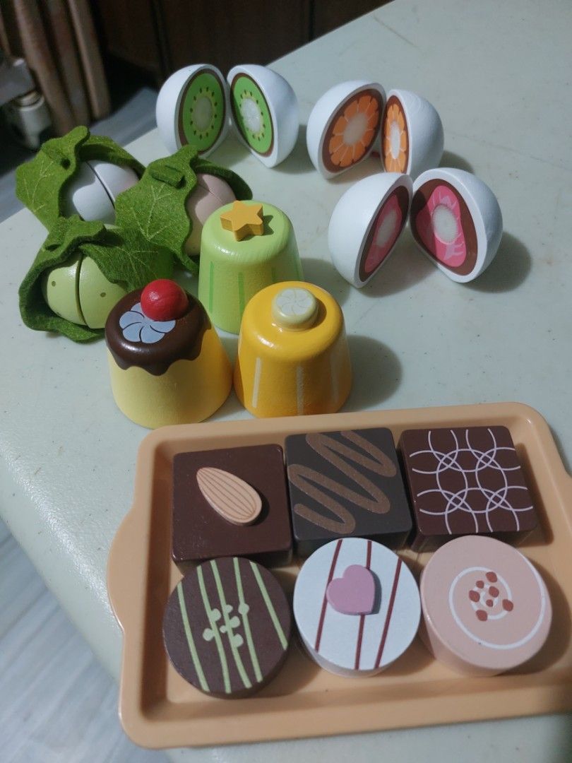 Wooden Play Food Set (Category: Kids Toys) located in Dagupan City. Submitted by scorpionel (Listing ID 1401081624, Image 1). Description: - Wooden play food set - Includes cuttable fruits, vegetables, and chocolates - Comes with a tray and wooden knife - Features colorful and detailed food pieces - Perfect for imaginative play - Helps kids learn about different foods.
