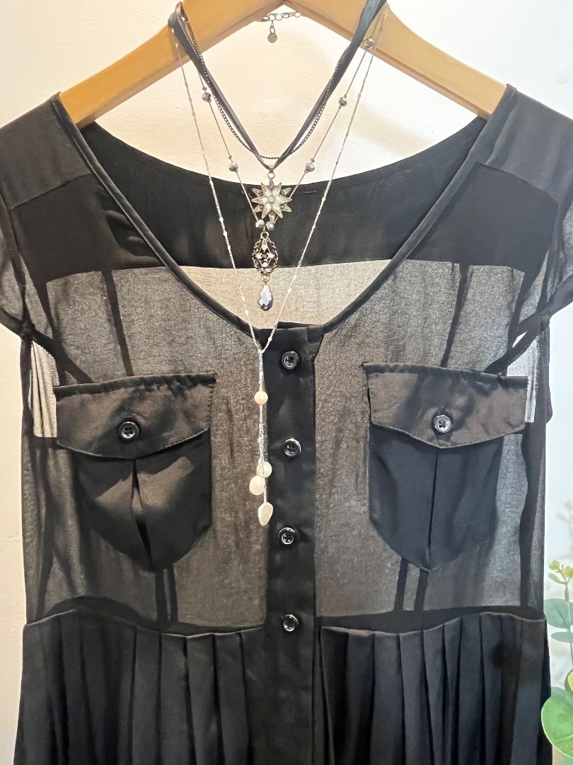 Black Maxi Dress with Sheer Overlay (Category: Dresses) located in Caloocan City. Submitted by allaboutaria (Listing ID 1396138604, Image 3). Description: Elegant black maxi dress featuring a sheer overlay on the bodice. It has short sleeves, two front pockets, and a button-down front. The dress has a pleated skirt, adding a touch of sophistication. Perfect for various occasions, offering a stylish and comfortable fit..