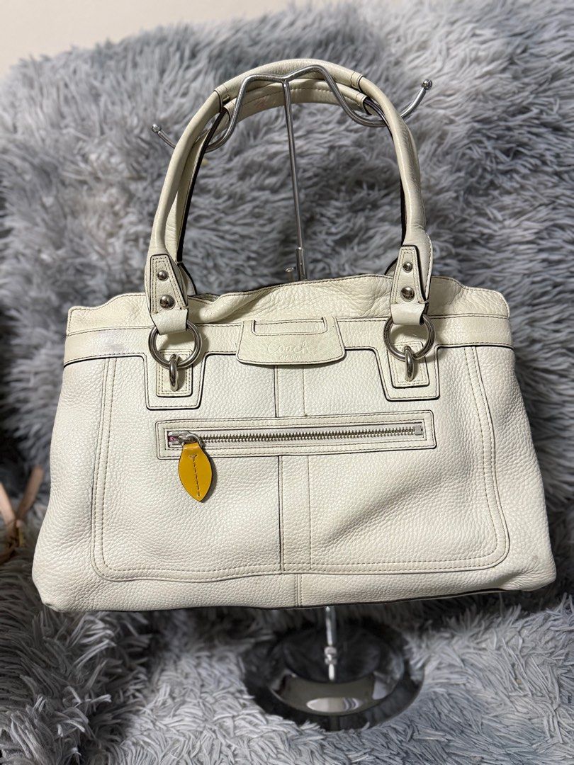 Coach White Leather Handbag (Category: Shoulder Bags) located in Cabanatuan. Submitted by closet-loop (Listing ID 1396141287, Image 1). Description: - White leather Coach handbag - Top zipper closure - Includes small yellow leather tag - Silver-tone hardware - Coach logo on front - Structured shape - Visible stitching details.