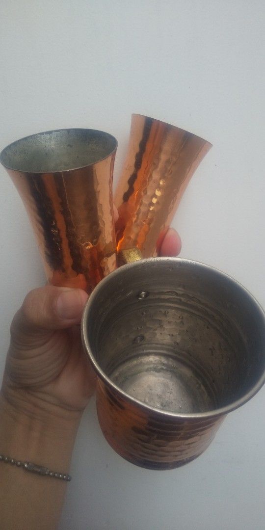 Copper Mugs Set (Category: Coffee & Tea Tableware) located in Carmona. Submitted by rpute (Listing ID 1396193468, Image 2). Description: - Set of 3 copper mugs - Includes two tall, flared mugs - Includes one shorter, cylindrical mug with a handle - All mugs feature a hammered texture - Warm copper color.