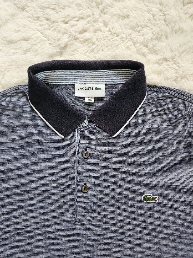 Lacoste Polo Shirt - Navy Blue (Category: Tshirts & Polo Shirts ) located in Davao. Submitted by workwear_stuff (Listing ID 1396136303, Image 2). Description: Width 21 Length 26 issue Collar not visivle pgsuot na - Navy blue Lacoste polo shirt - Size: M - Classic collar with white trim - Features the iconic Lacoste logo - Textured pattern - Short sleeves with contrasting black and white cuffs.